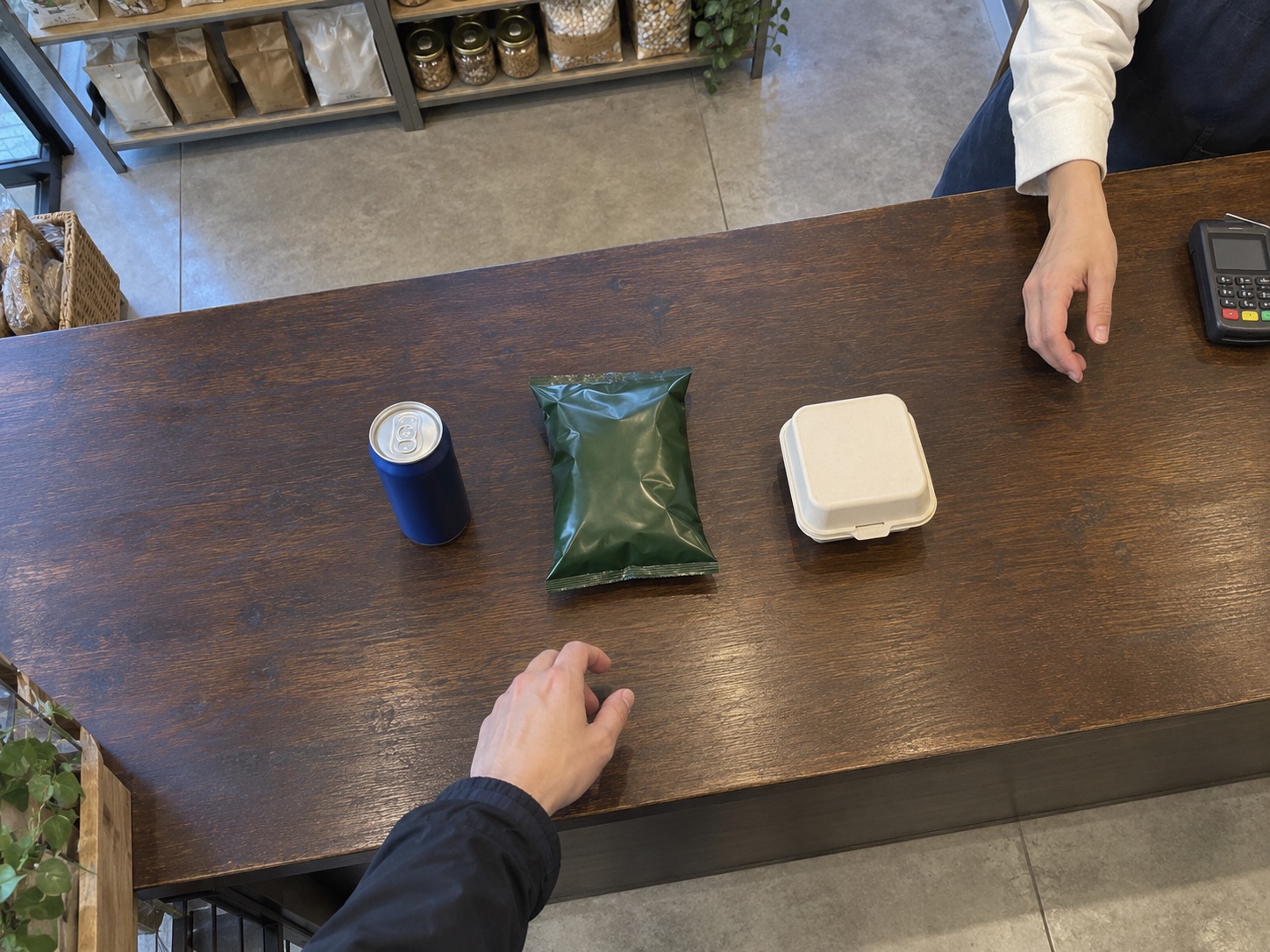 Illustrative overhead checkout view with a drink, snack bag and food carton.